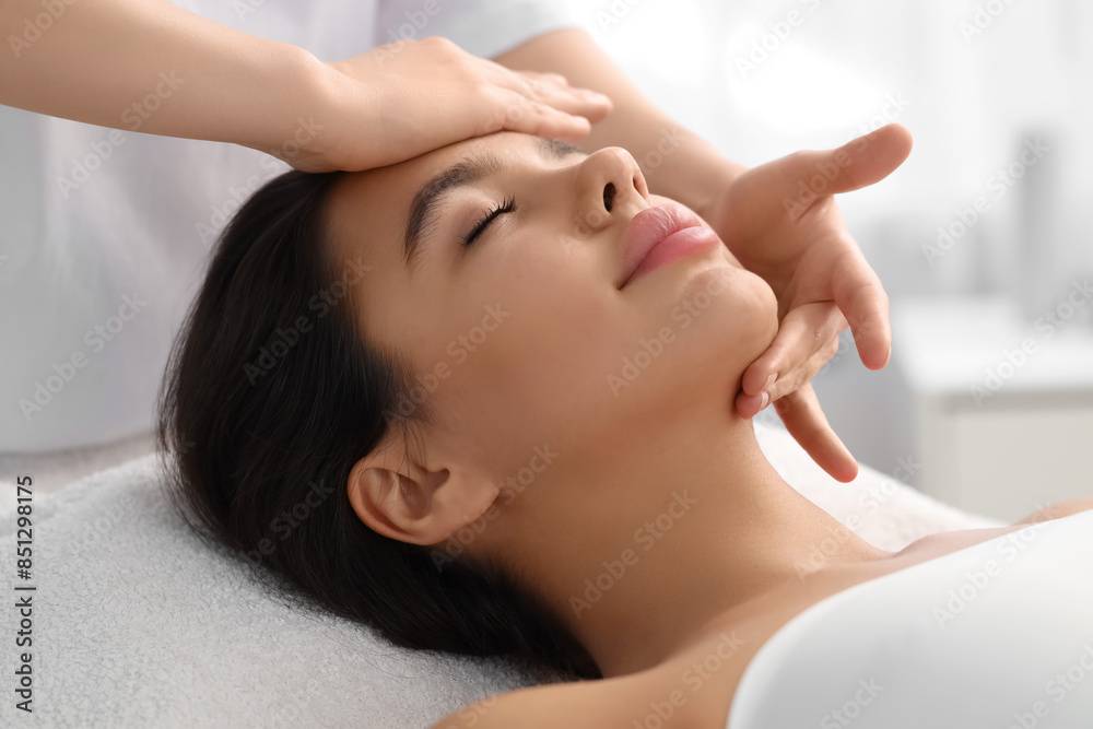 Young woman having facial massage in salon, closeup Young woman having facial massage in salon, closeup