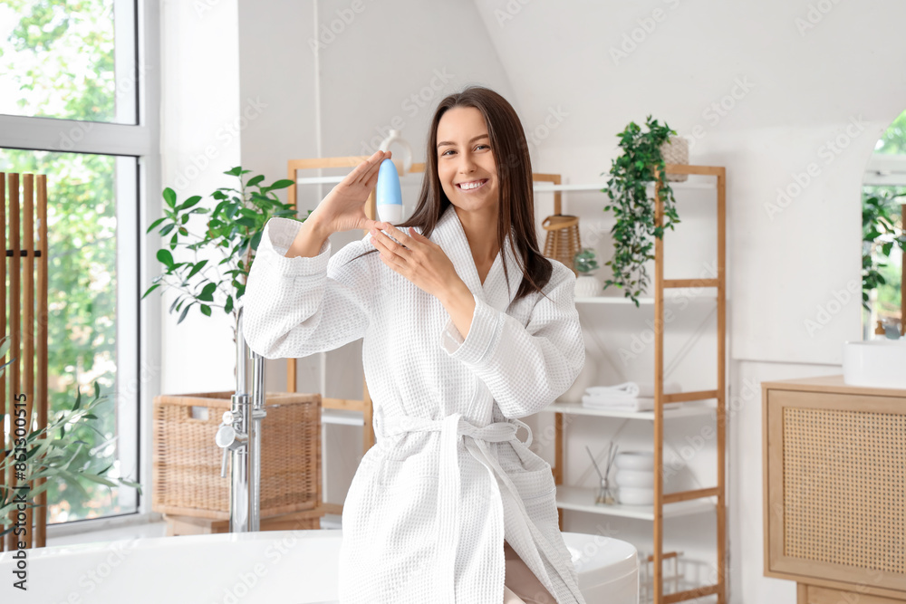 Beautiful young happy woman with deodorant in bathroom at home Beautiful young happy woman with deodorant in bathroom at home