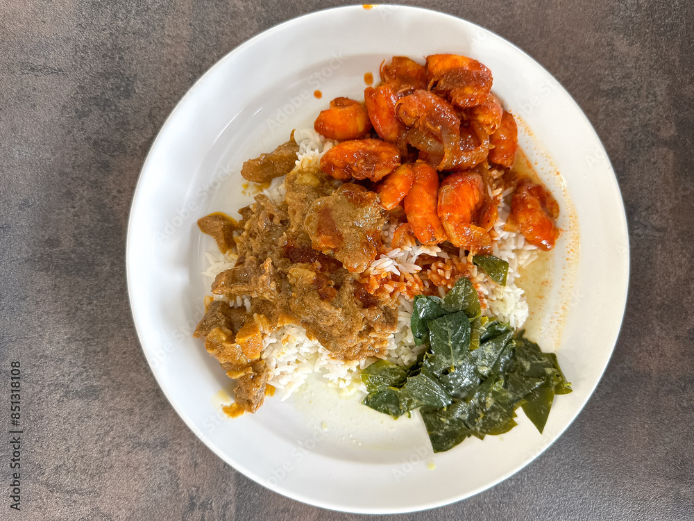 Malaysian styled complete meal for lunch or dinner called Nasi Campur. It is plain white rice served with variety of dishes. Malaysian styled complete meal for lunch or dinner called Nasi Campur. It is plain white rice served with variety of dishes.