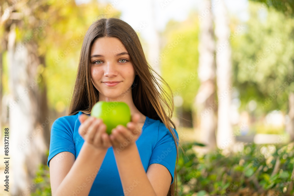 Teenager girl at outdoors holding an apple Teenager girl at outdoors holding an apple
