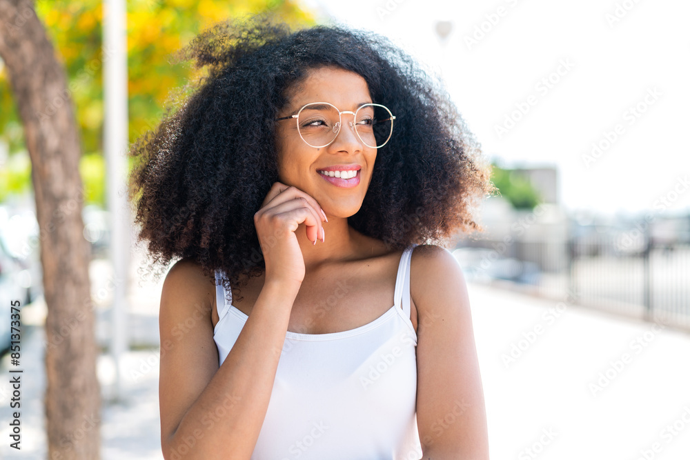 Young African American woman at outdoors With glasses and thinking while looking up