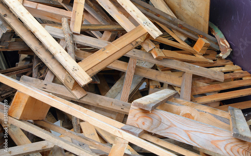 wooden pieces planks and pallets in the wood recycling container at the landfill for proper waste disposal