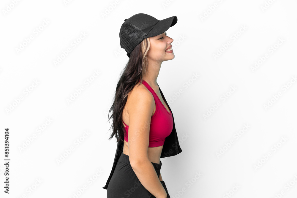 Sport Russian girl with hat and towel isolated on white background laughing in lateral position Sport Russian girl with hat and towel isolated on white background laughing in lateral position