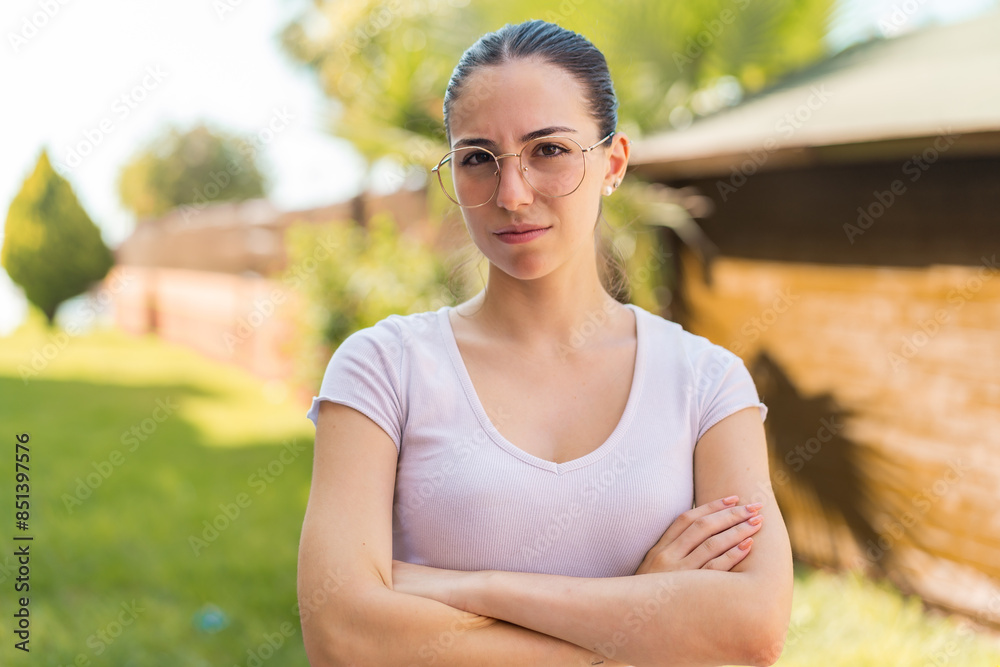 Young pretty woman at outdoors With glasses and arms crossed Young pretty woman at outdoors With glasses and arms crossed