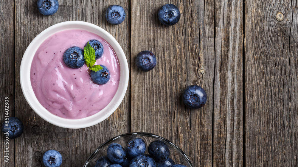 Homemade yogurt with fresh blueberry on a wooden background. Homemade yogurt with fresh blueberry on a wooden background.