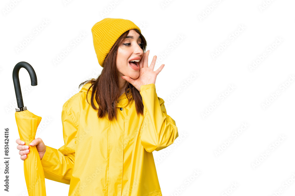Young caucasian woman with rainproof coat and umbrella over isolated chroma key background shouting with mouth wide open to the side Young caucasian woman with rainproof coat and umbrella over isolated chroma key background shouting with mouth wide open to the side