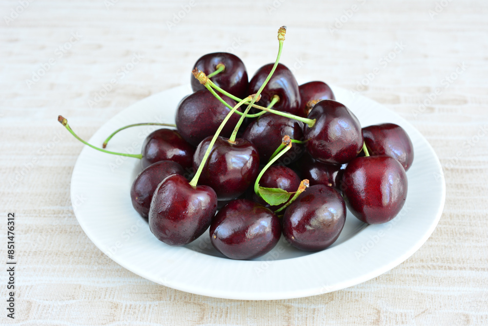a plate of cherries with green stems a plate of cherries with green stems