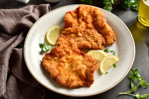 Schilderij op canvas Schnitzel with lemon and leaves of parsley