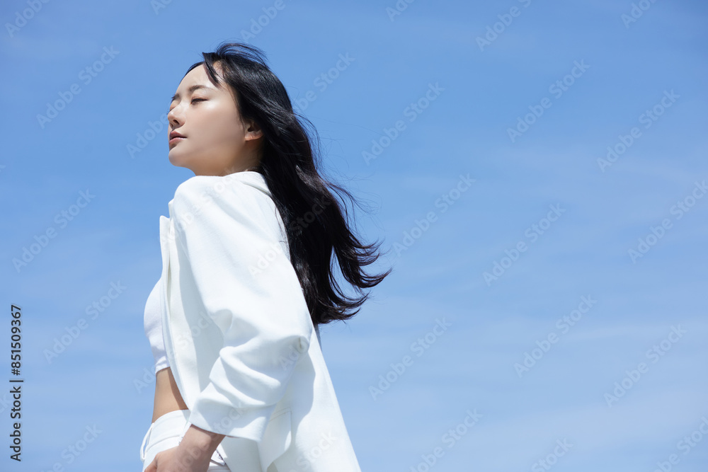 空背景で撮影をした白いジャケットを着た若いアジア女性のポートレート 空背景で撮影をした白いジャケットを着た若いアジア女性のポートレート