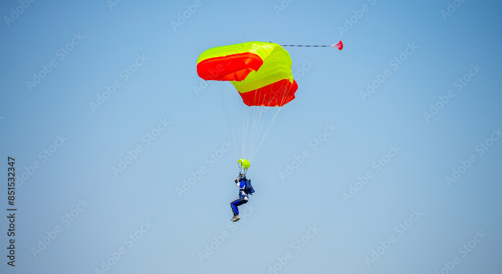 Skydiving. Flying parachutists against the background of the blue sky and mountains. Extreme sport and entertainment.