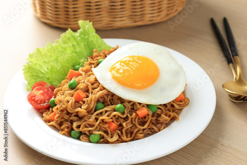 Close Up Indomie Goreng, Stir Fried Instant Noodles with Sunny Side Egg on Top. photo