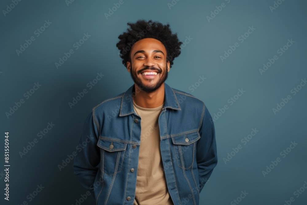 Portrait of a happy afro-american man in his 20s wearing a rugged jean vest on blank studio backdrop Portrait of a happy afro-american man in his 20s wearing a rugged jean vest on blank studio backdrop