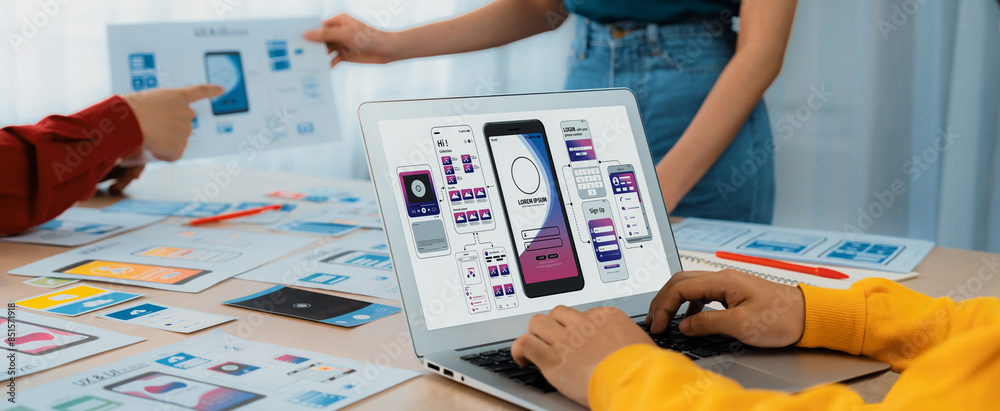 © InfiniteFlow - Panorama banner of startup UX developer or company employee design user interface or UI prototype for mobile application or website software with software display on laptop monitor in office. Synergic