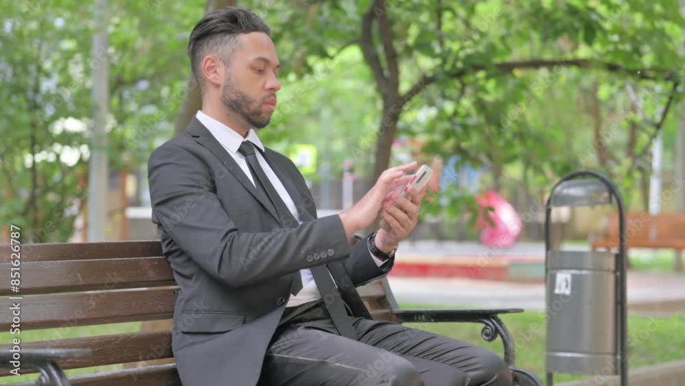 Mixed Race Businessman Using Smartphone while Sitting Outdoor Mixed Race Businessman Using Smartphone while Sitting Outdoor