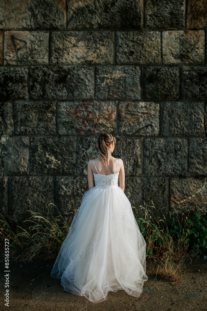 A bride stands facing away, showcasing her elegant wedding dress in various serene and picturesque settings, capturing the quiet moments of reflection and anticipation before the ceremony. A bride stands facing away, showcasing her elegant wedding dress in various serene and picturesque settings, capturing the quiet moments of reflection and anticipation before the ceremony.