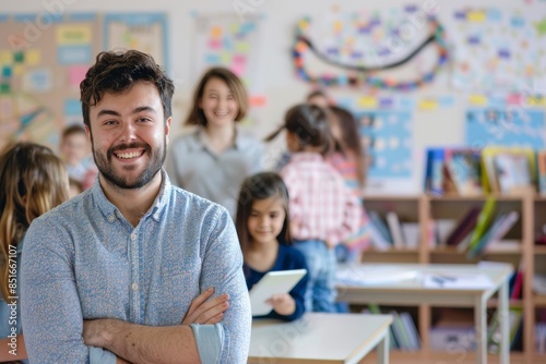A man is smiling and holding a tablet in front of a group of children