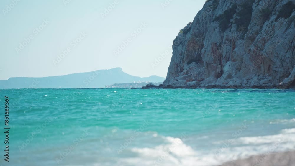 top view from high cliff on calm sea with turquoise colored water at rocky pebble beach in Antalya region, Turkey. amazing wild nature and seascape. summertime and tourism concept.
