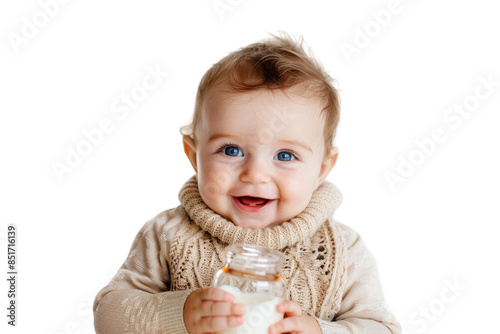 A cheerful baby in a cream-colored sweater holds a glass bottle of milk
