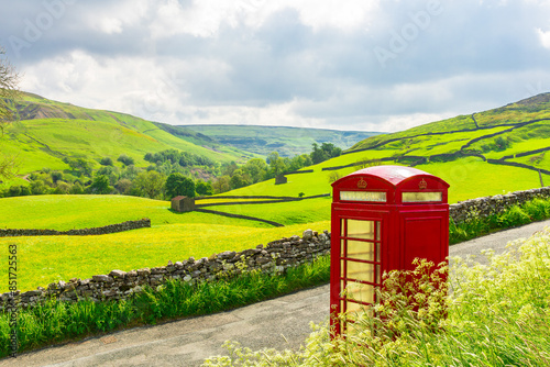 Fotografie Iconic old-fashioned red telephone box in Keld, Swaledale, Yorkshire Dales, overlooking the  colourful wildflower meadows, drystone walling and stone barns