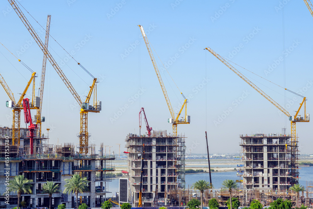 Naklejka premium residential buildings under construction with cranes at construction site
