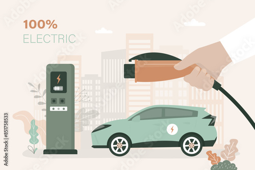 Closeup driver hand holds plug for charges modern electric car at charging station. City landscape on background. Ecologically clean transport,