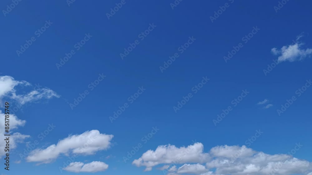 Small cotton-like clouds move across the blue sky in the afternoon Small cotton-like clouds move across the blue sky in the afternoon