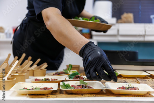 Traiteur préparant des portions individuelles lors d'un événement d'entreprise
