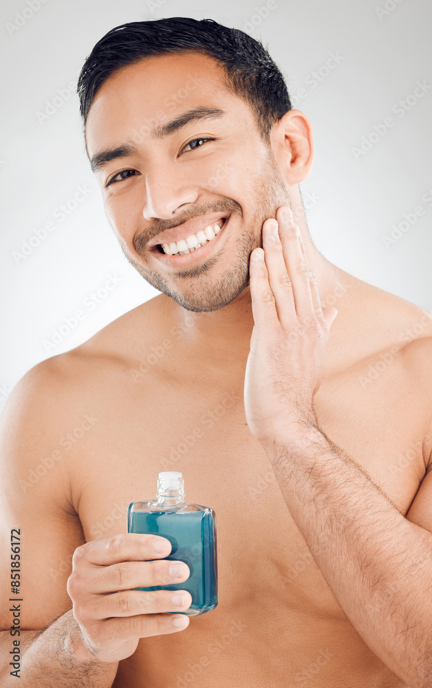 © peopleimages.com - Portrait, man and bottle of aftershave with skincare for razor burn and hair removal in studio. Dermatology, male person and cosmetics product for sensitive skin and cleaning face by white background