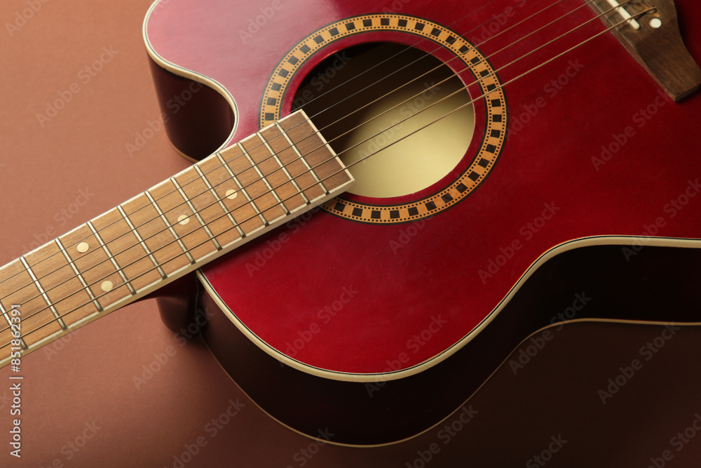 Obraz premium Detail of red guitar on brown background. Space for text