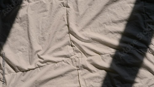 female hand reaching for a pink sex toy rabbit shaped vibrator for women in bed, sun rays on a blanket, good morning bedroom concept