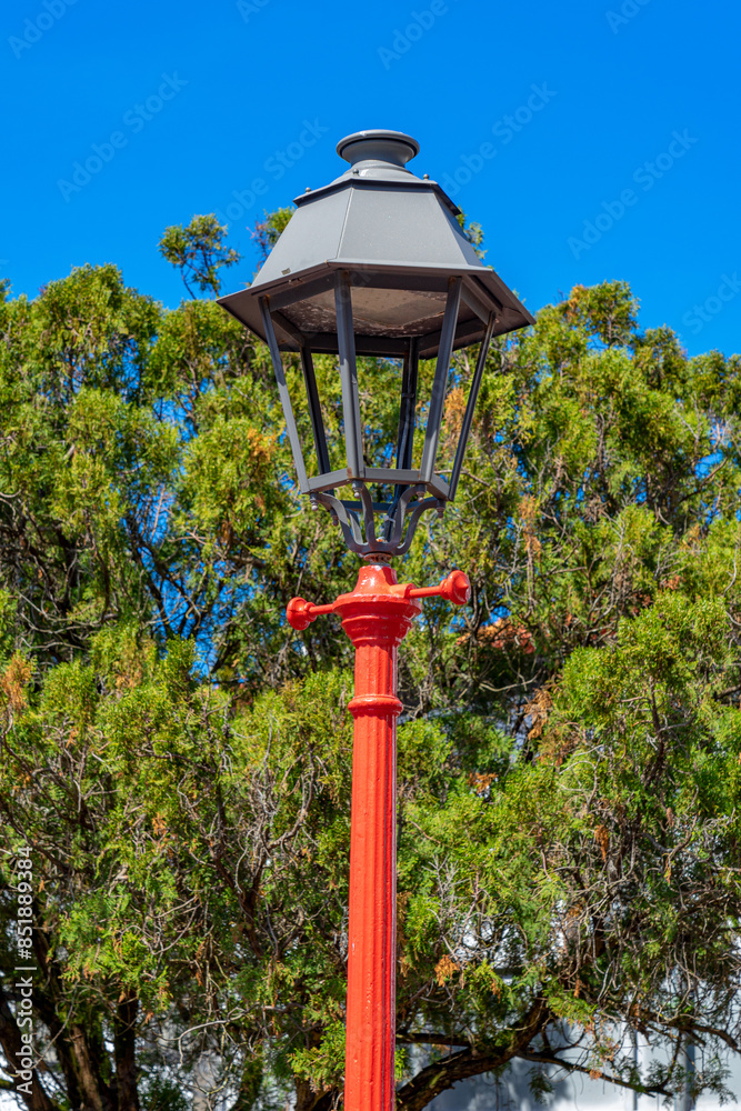red and black vertical lamp with great contrast inside the municipal garden of República de Velas, São Jorge Island-Azores-Portugal red and black vertical lamp with great contrast inside the municipal garden of República de Velas, São Jorge Island-Azores-Portugal