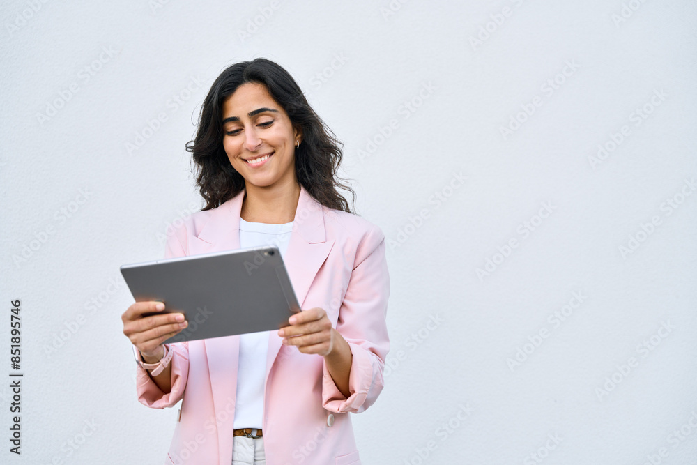 Smiling young middle eastern Israel businesswoman using tablet pc online application for work isolated on white background. Indian or arabic woman in business suit holding digital computer. Copy space Smiling young middle eastern Israel businesswoman using tablet pc online application for work isolated on white background. Indian or arabic woman in business suit holding digital computer. Copy space