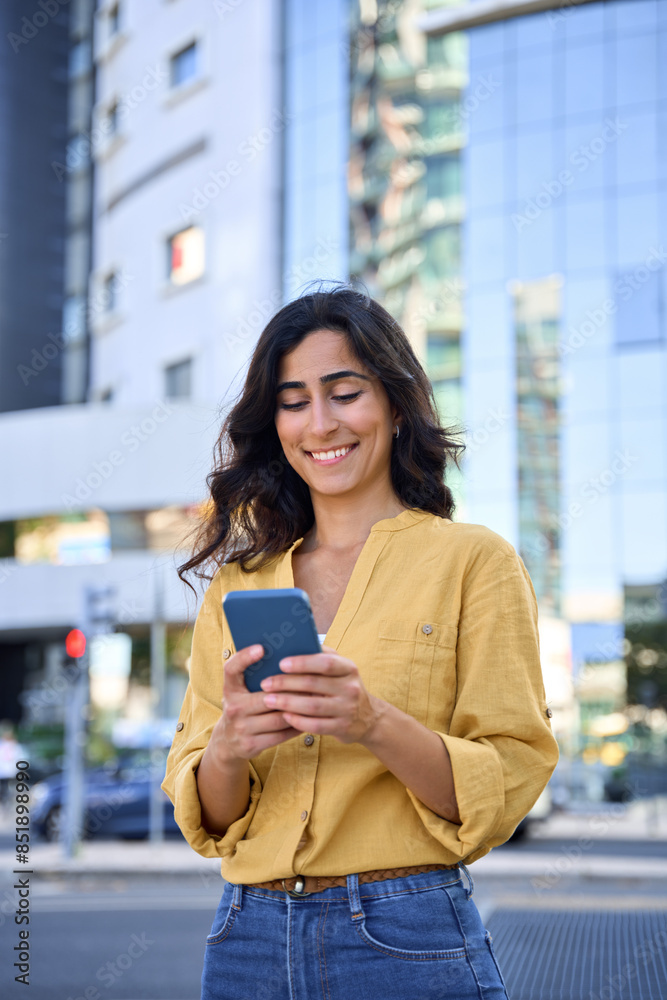 Φωτογραφία Smiling indian arabic student woman in casual shirt holding cellphone for online business work application