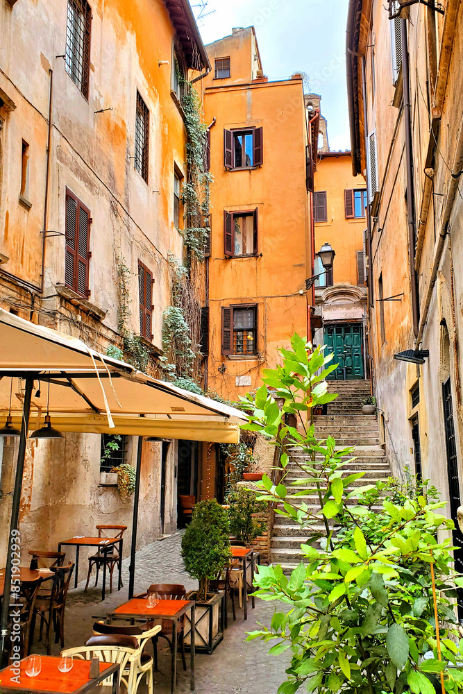 Obraz premium Quaint restaurant in the colorful narrow lanes of historic Rome, Italy