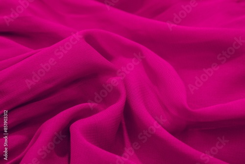 Close-up of vibrant magenta fabric with soft folds and texture