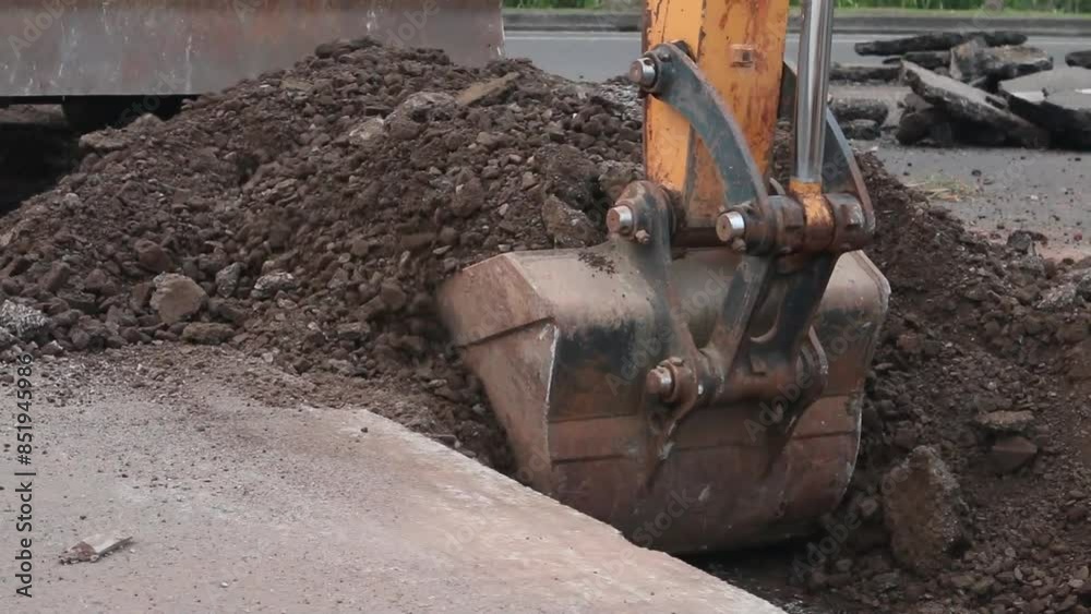 Excavator digs trench in the construction site, close up backhoe digger