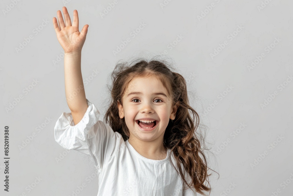 Little girl with raised hand, her joyful expression a symbol of innocent happiness and beauty. Little girl with raised hand, her joyful expression a symbol of innocent happiness and beauty.