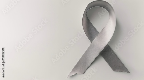 A brain cancer awareness ribbon in a soothing shade of gray stands out against a clean white background complete with a clipping path photo