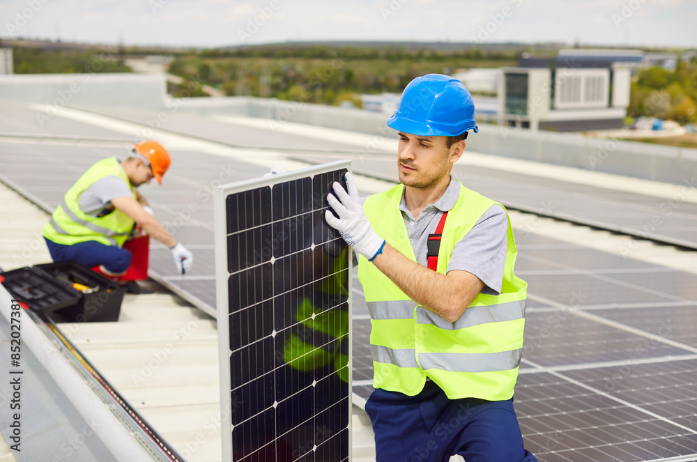 Engineer inspects solar panels before installation on the roof. Worker inspection ensures the quality and readiness of the photovoltaic system, contributing to renewable energy production. Engineer inspects solar panels before installation on the roof. Worker inspection ensures the quality and readiness of the photovoltaic system, contributing to renewable energy production.