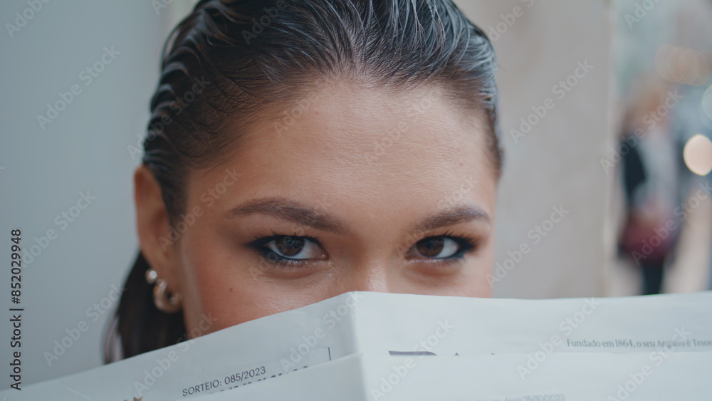 Girl hiding face newspaper sitting urban street close up. Portrait elegant lady Girl hiding face newspaper sitting urban street close up. Portrait elegant lady
