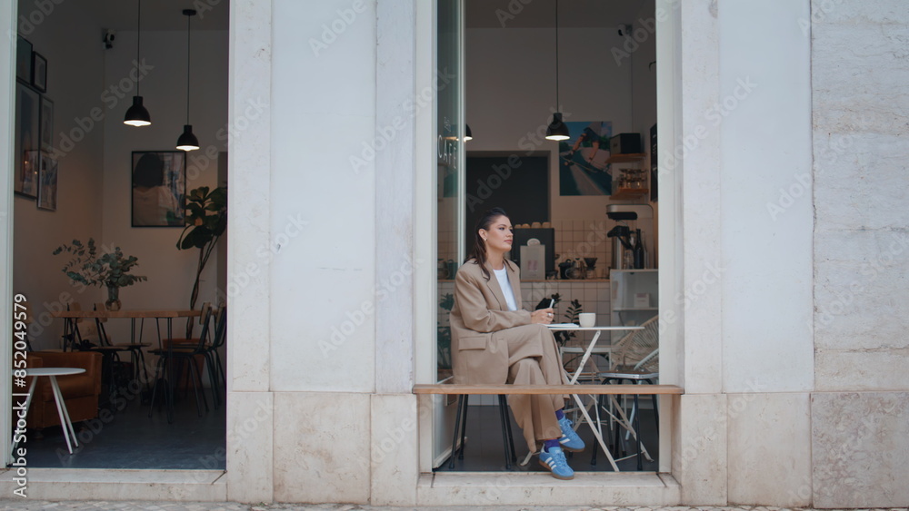 Gorgeous freelancer resting cafe table looking on urban street. Elegant woman Gorgeous freelancer resting cafe table looking on urban street. Elegant woman
