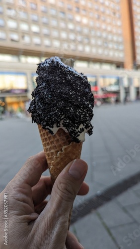 Eis mit Lakritze und Waffel in der Hand
