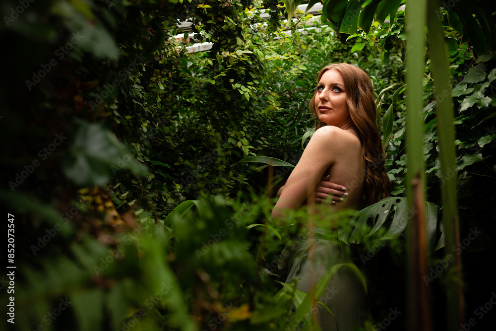 Naked girl model in the tropical forest. Curly hair, professional makeup