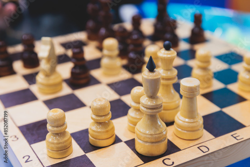 Chess tournament, kids and adults participate in chess match game in indoor hall, players of all ages play, competition in chess school club with chessboards on a table, wooden pieces