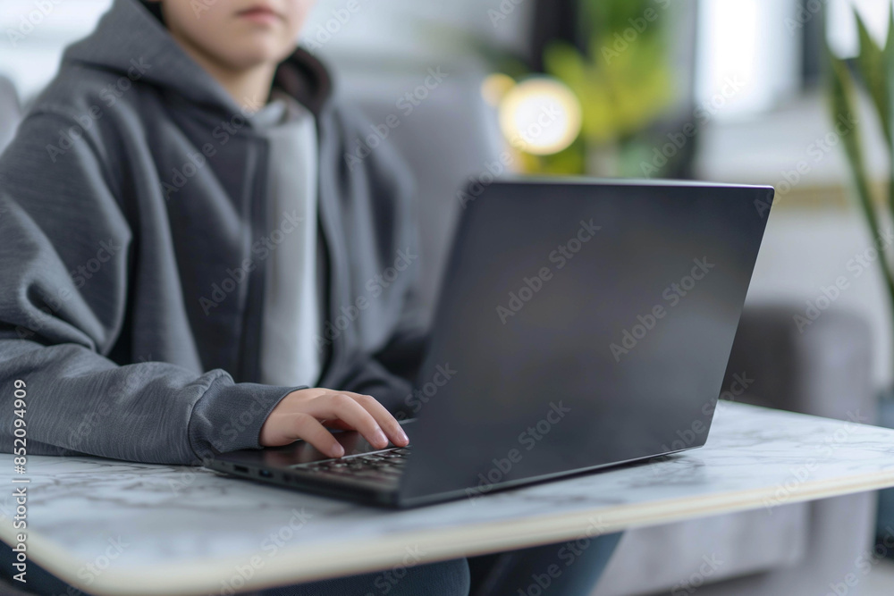 A child sits in a modern bright room in a minimalist style with a laptop and studies, distance learning concept for schoolchildren. A child sits in a modern bright room in a minimalist style with a laptop and studies, distance learning concept for schoolchildren.