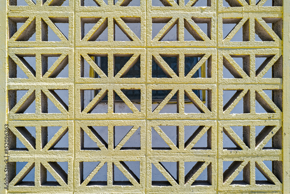 A decorative concrete block divider wall with a repeating geometric pattern A decorative concrete block divider wall with a repeating geometric pattern