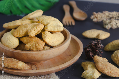 fish-shaped bahulu cake in a wooden bowl.  similar to a madeleine cake but in the shape of a fish photo