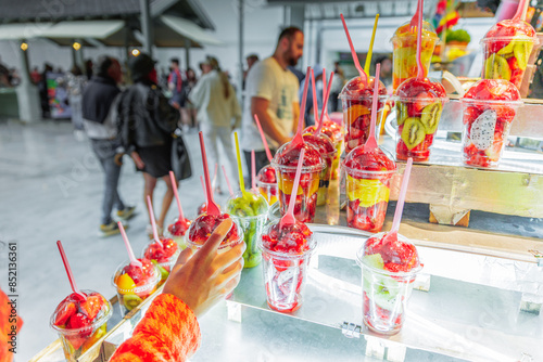 Glasses with cut natural fruit inside and a hand holding one