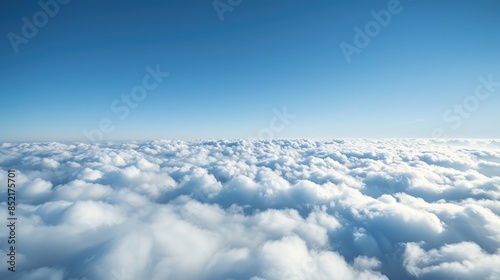 Fototapeta Naklejka Na Ścianę i Meble -  Bird s eye view over a blanket of clouds under a clear blue sky