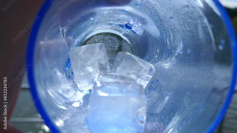 Ice cubes in plastic drinking cup swirled around
